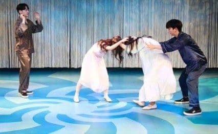 Production still — ensemble scene
