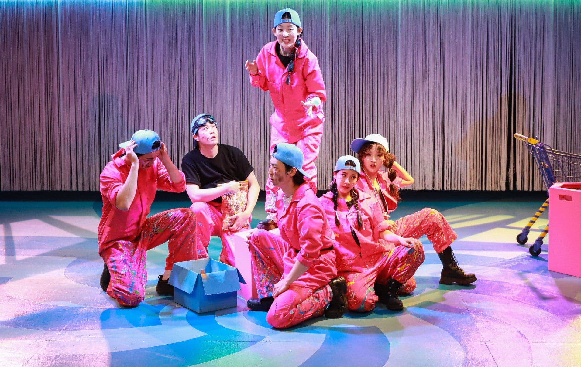 A Midsummer Night's Dream — ensemble in pink factory uniforms on the Dream Corporation stage